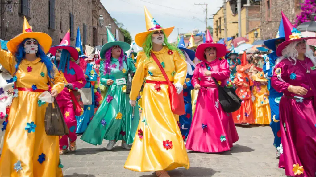 Participants dressed in colorful costumes and face paint during a festive parade in San Miguel de Allende.