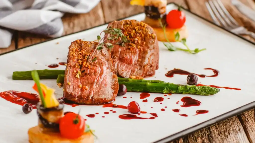 Gourmet steak served with asparagus, berry reduction, and microgreens ā representing the elevated dining scene in San Miguel de Allende