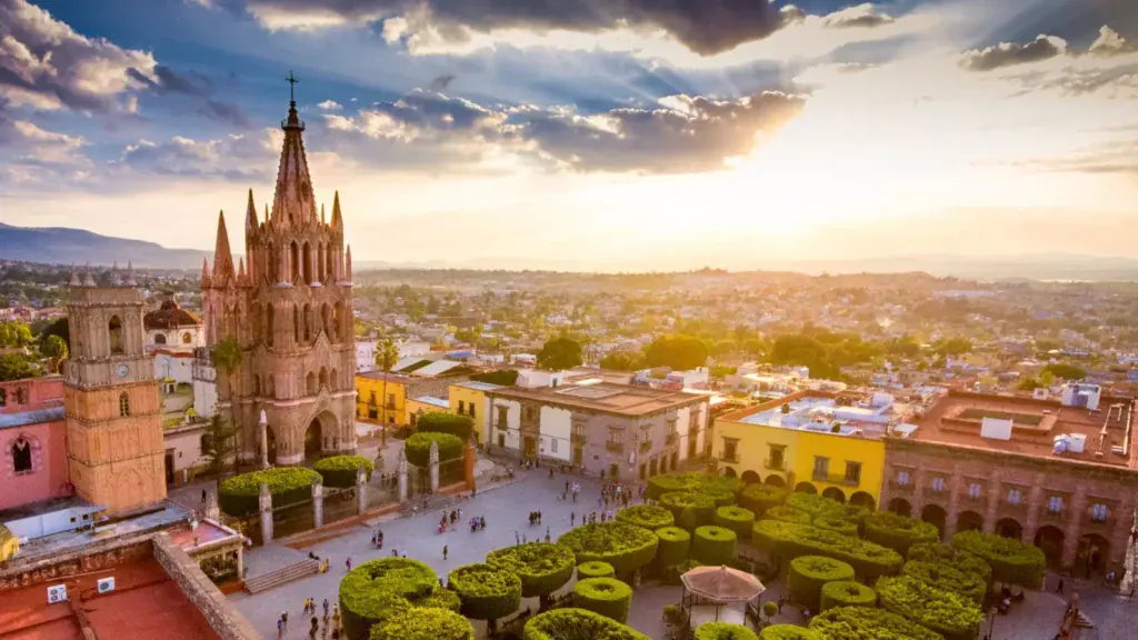 Aerial view of San Miguel de Allende at sunset showcasing the Parroquia and historic city center ā a symbol of luxury living and cultural heritage in Mexico.