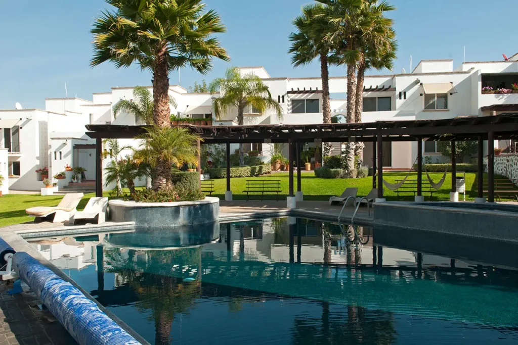Pool area with palm trees and modern homes in the Paseo Real community of San Miguel de Allende.