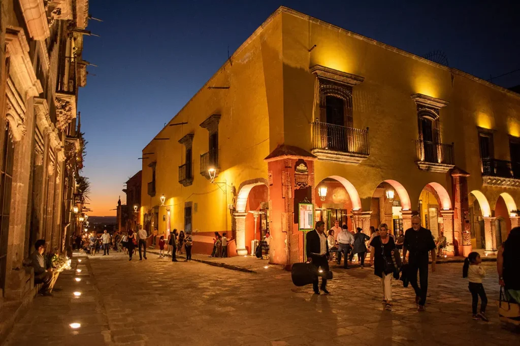 Evening plaza life in Centro San Miguel de Allende with colonial architecture and residents gathering