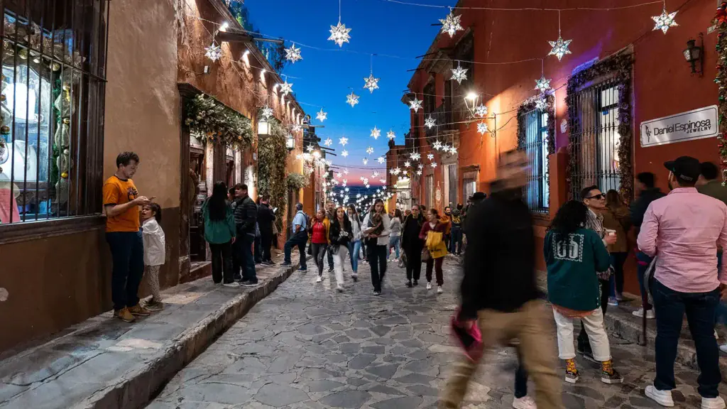 Evening street life in San Miguel de Allende with cobblestones, colonial buildings, and vibrant community