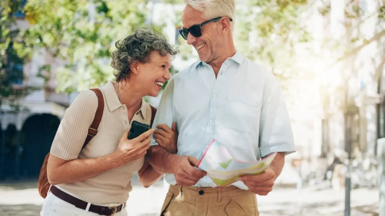 Retiring in San Miguel de Allende - Why This City Tops the List - Colonial Real Estate - Colonial Real Estate Happy retired couple exploring San Miguel de Allende with a map, enjoying outdoor city life as foreign residents in Mexico